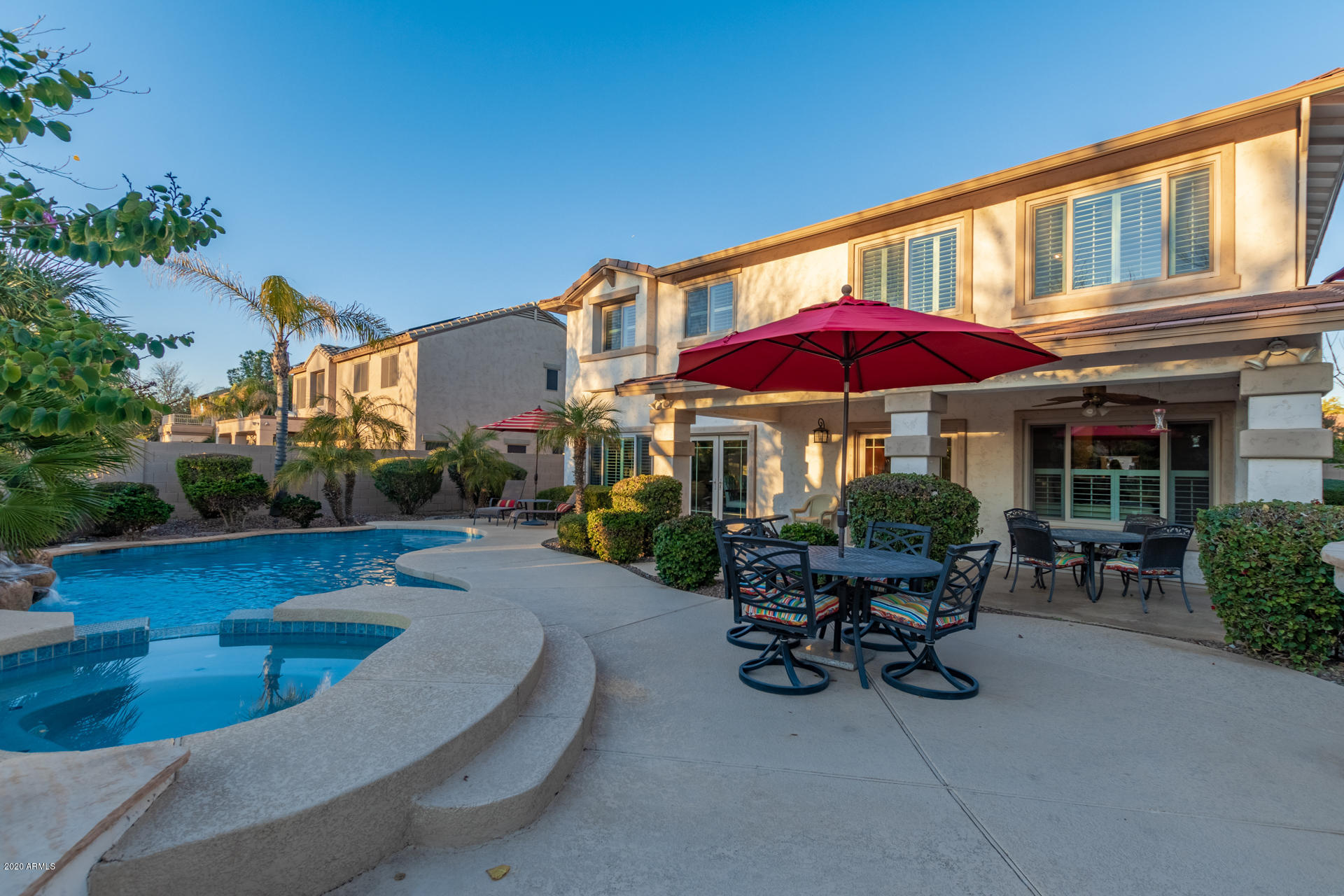 4549 East Ruffian Road Gilbert, AZ 85297 - Photo 22 of 52 a view of a patio with a table and chairs under an umbrella