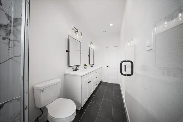 a bathroom with a double vanity sink toilet and shower