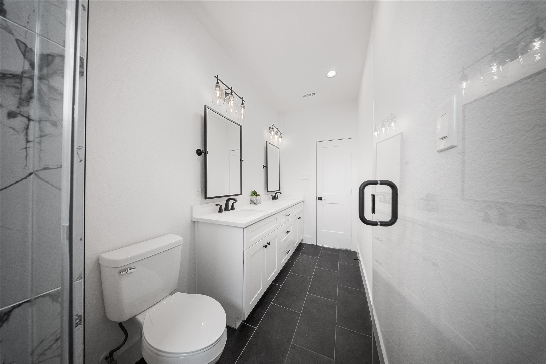 1122 Hogan Street Houston, TX 77009 - Photo 15 of 32 a bathroom with a double vanity sink toilet and shower