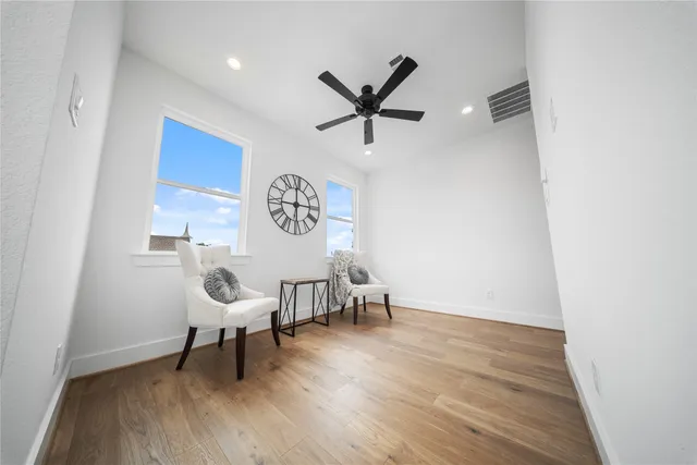 a view of a workspace with furniture and wooden floor