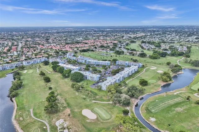 an aerial view of a residential houses with outdoor space and trees