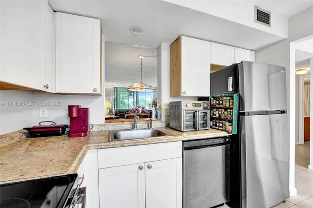 a kitchen with stainless steel appliances granite countertop a refrigerator and a sink