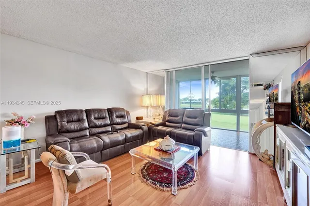 a living room with furniture a flat screen tv and a large window