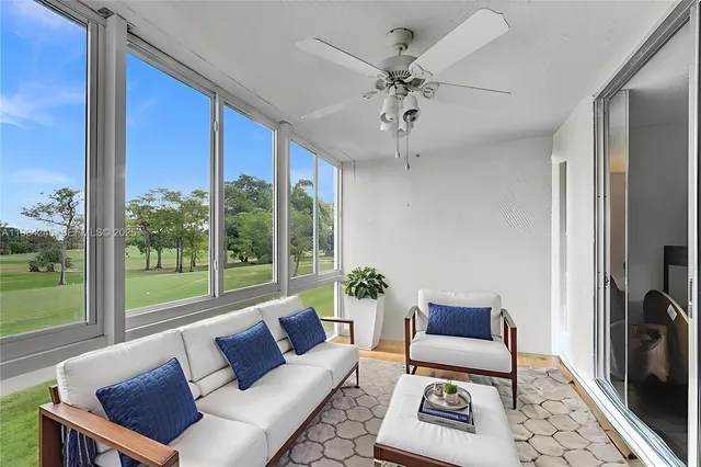 a living room with furniture and a floor to ceiling window