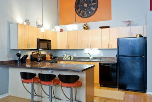 203 South Sangamon Street, Unit 310 Chicago, IL 60607 - Photo 7 of 16 a kitchen with stainless steel appliances granite countertop a stove a refrigerator a sink a dining table and chairs with wooden floor