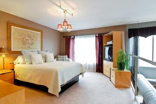 203 South Sangamon Street, Unit 310 Chicago, IL 60607 - Photo 8 of 16 a spacious bedroom with a bed and a chandelier