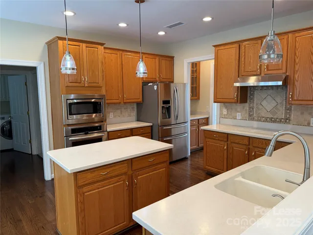 a kitchen with stainless steel appliances a sink stove and refrigerator