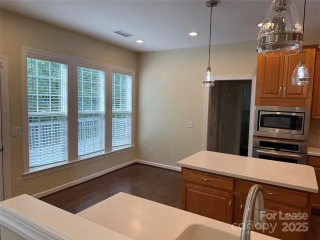 a kitchen with a refrigerator and a stove top oven