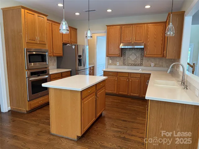 a kitchen with stainless steel appliances granite countertop a sink stove and refrigerator