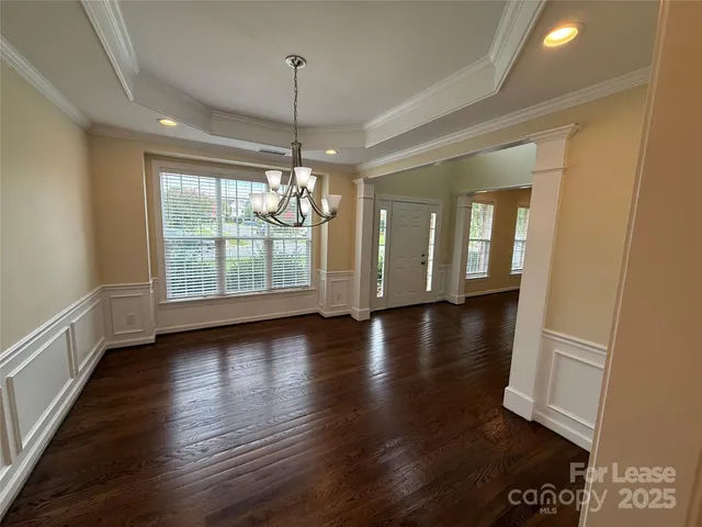 an empty room with wooden floor and large windows