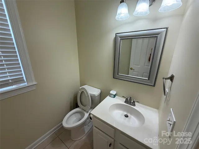 a bathroom with a toilet sink vanity and mirror