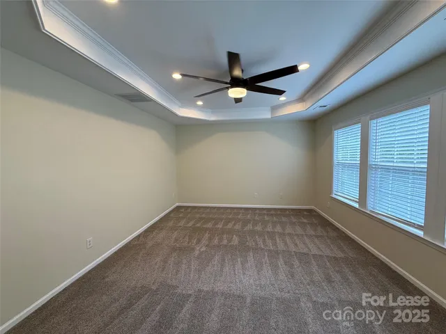 an empty room with a window and a ceiling fan
