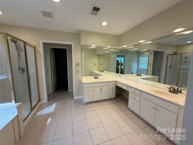 a large kitchen with a sink and white cabinets