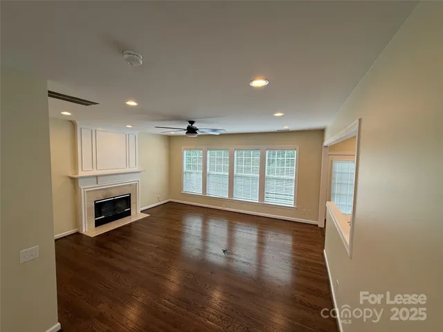 a view of an empty room with a fireplace and a window