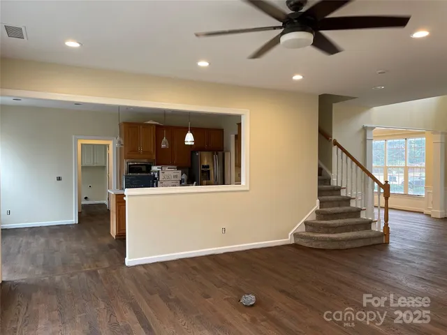 a view of a hallway with wooden floor and staircase