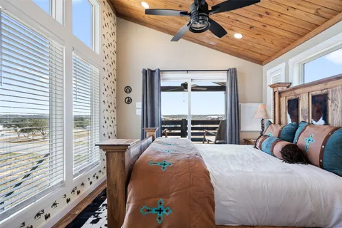 a large bedroom with a bed and large windows