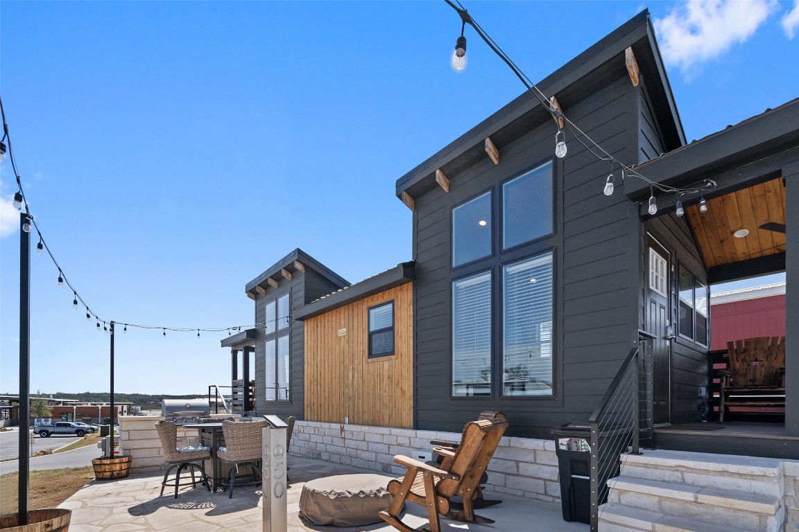 5386 Ranch Road 1376, Unit 50 Fredericksburg, TX 78624 - Photo 21 of 32 a view of a patio with table and chairs with wooden floor and fence
