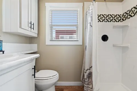 a bathroom with a sink a toilet and shower