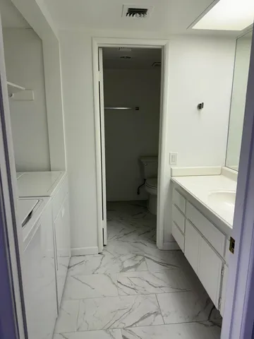 a white toilet sitting next to a shower