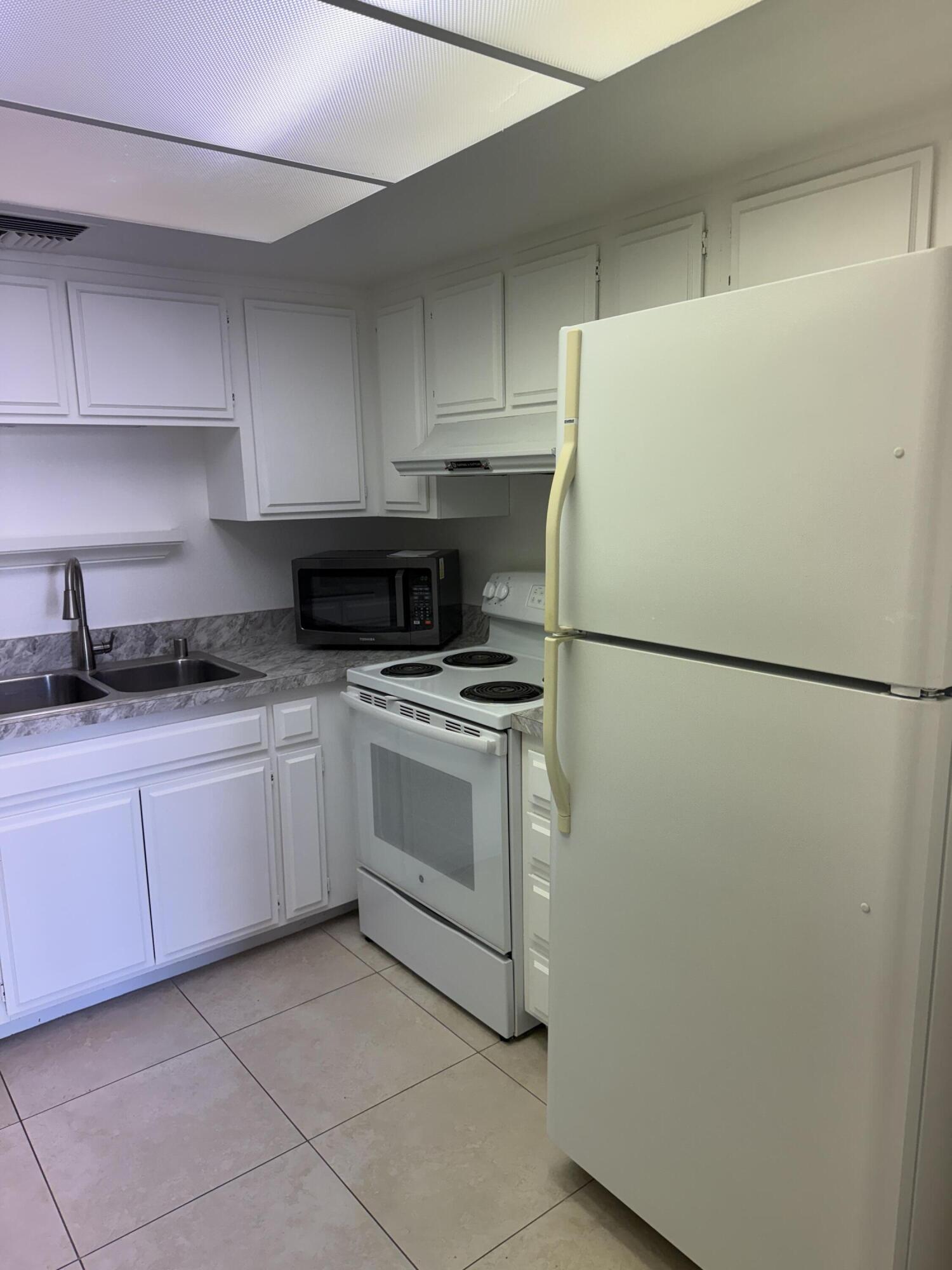 2017 Normandy Court Palm Springs, CA 92264 - Photo 5 of 17 a kitchen with cabinets and white stainless steel appliances