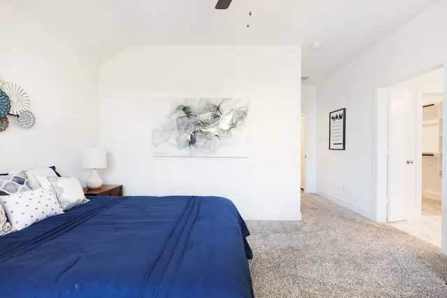 a bedroom with a bed and a painting on the wall