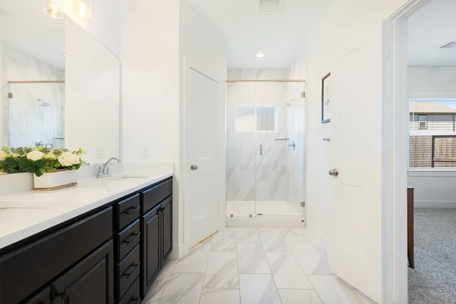 a bathroom with a shower sink and mirror