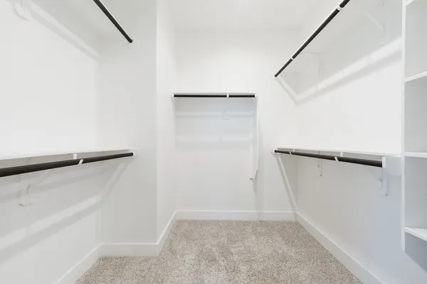 a view of walk in closet with empty racks