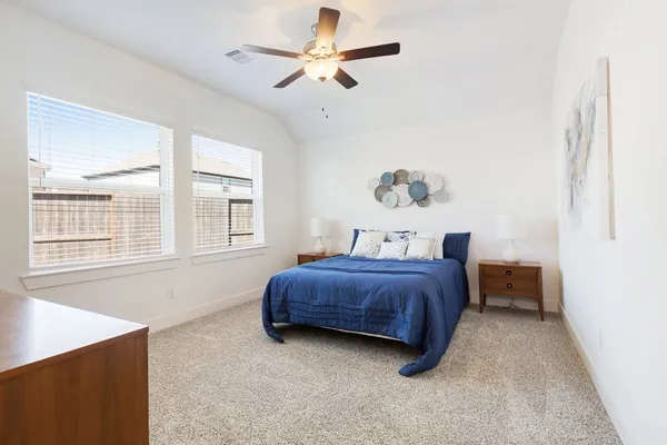 a spacious bedroom with a bed dresser and a window