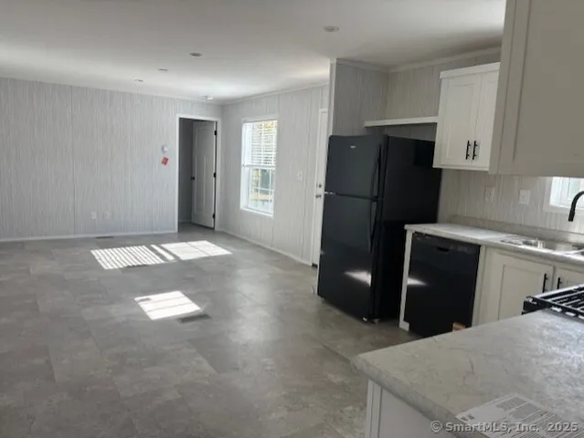 a kitchen with stainless steel appliances granite countertop a refrigerator a stove a sink and dishwasher