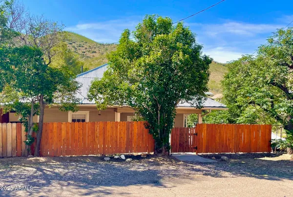 a view of wooden fence under a large tree