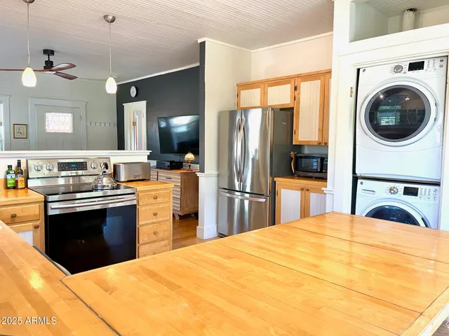a kitchen with stainless steel appliances granite countertop a stove a sink and a granite counter tops with white cabinets next to a window