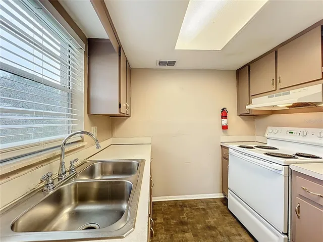 a kitchen with sink a stove and cabinets
