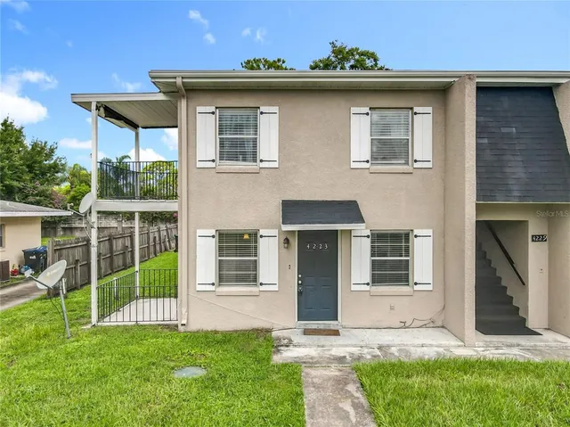 a front view of a house with a yard and potted plants