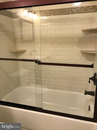 a bathroom with a shower and a bath tub