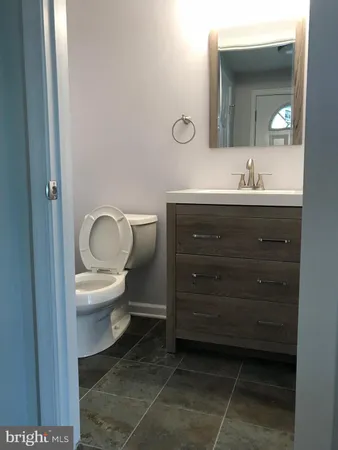 a bathroom with a toilet a sink and mirror