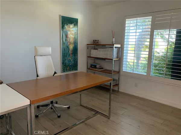 a view of a workspace with furniture and a window