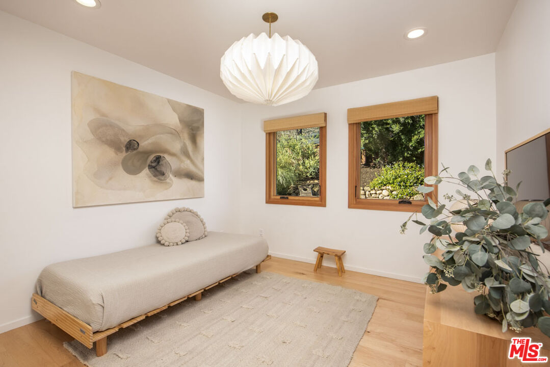 530 Pleasant Avenue Ojai, CA 93023 - Photo 15 of 29 a bedroom with a bed and a chandelier