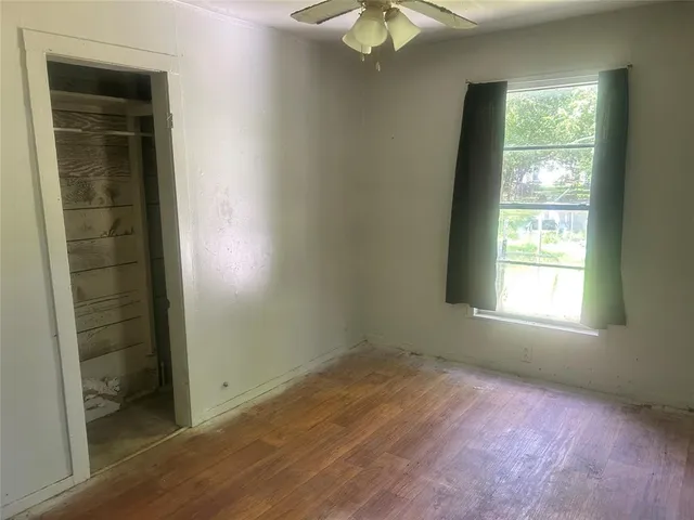 an empty room with windows and closet