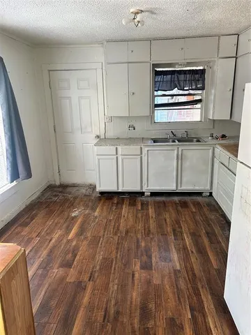 a kitchen with granite countertop white cabinets and white appliances