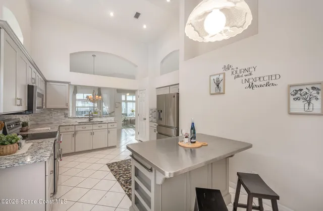 a kitchen with a sink a stove and chairs