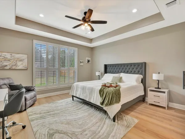 a spacious bedroom with a bed a chandelier and a large window
