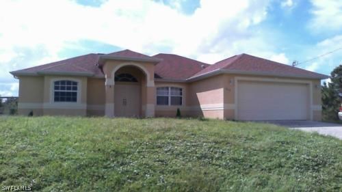 4015 36th Street Southwest Lehigh Acres, FL 33976 - Photo 1 of 23 a front view of a house with a yard