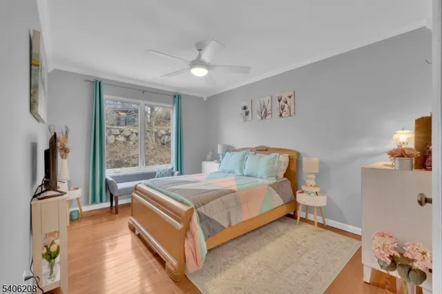 a bedroom with a bed and a flat tv screen on the dresser