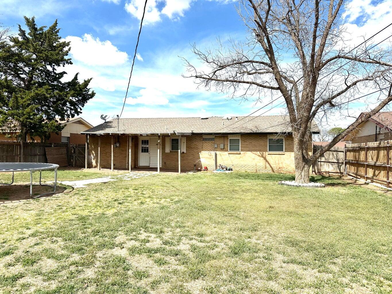 2615 West 19th Plainview, TX 79072 - Photo 14 of 15 a front view of a house with a garden and trees