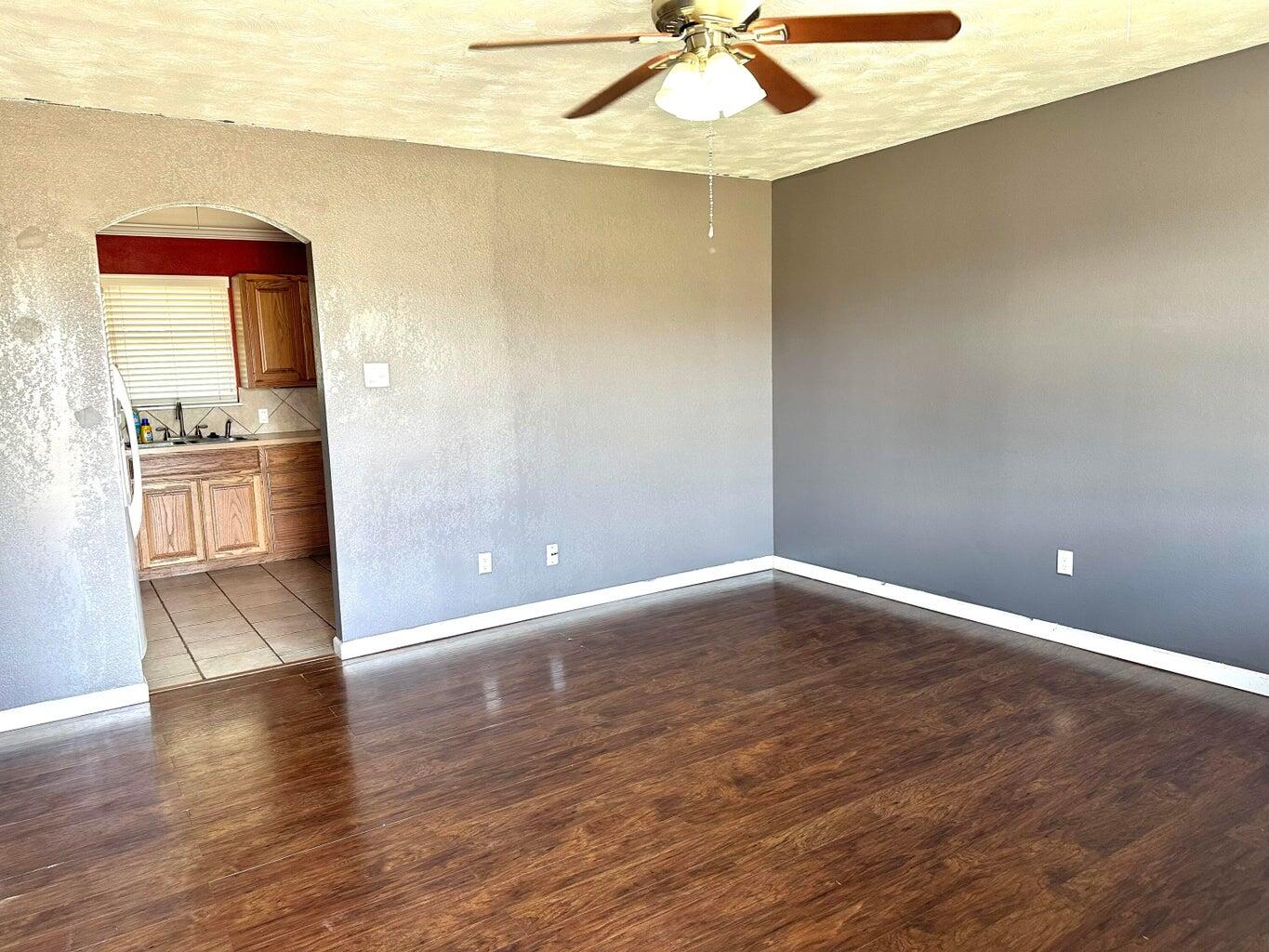 2615 West 19th Plainview, TX 79072 - Photo 2 of 15 a view of an empty room with a window and wooden floor