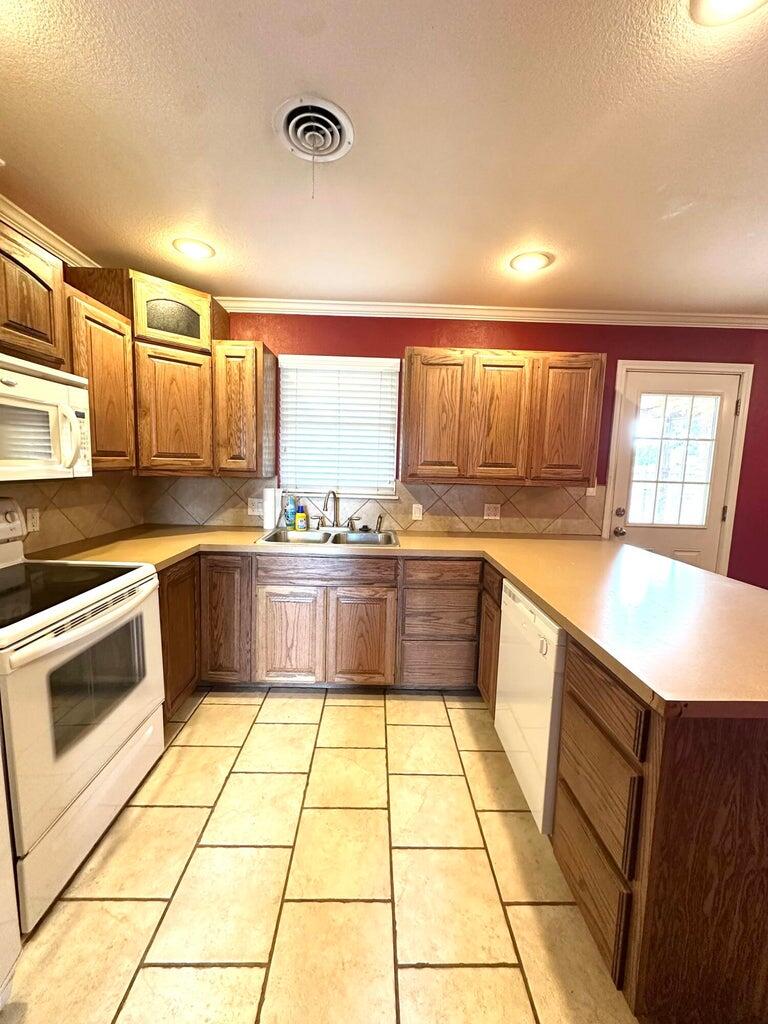 2615 West 19th Plainview, TX 79072 - Photo 3 of 15 a kitchen with a cabinets a counter top space a sink and appliances