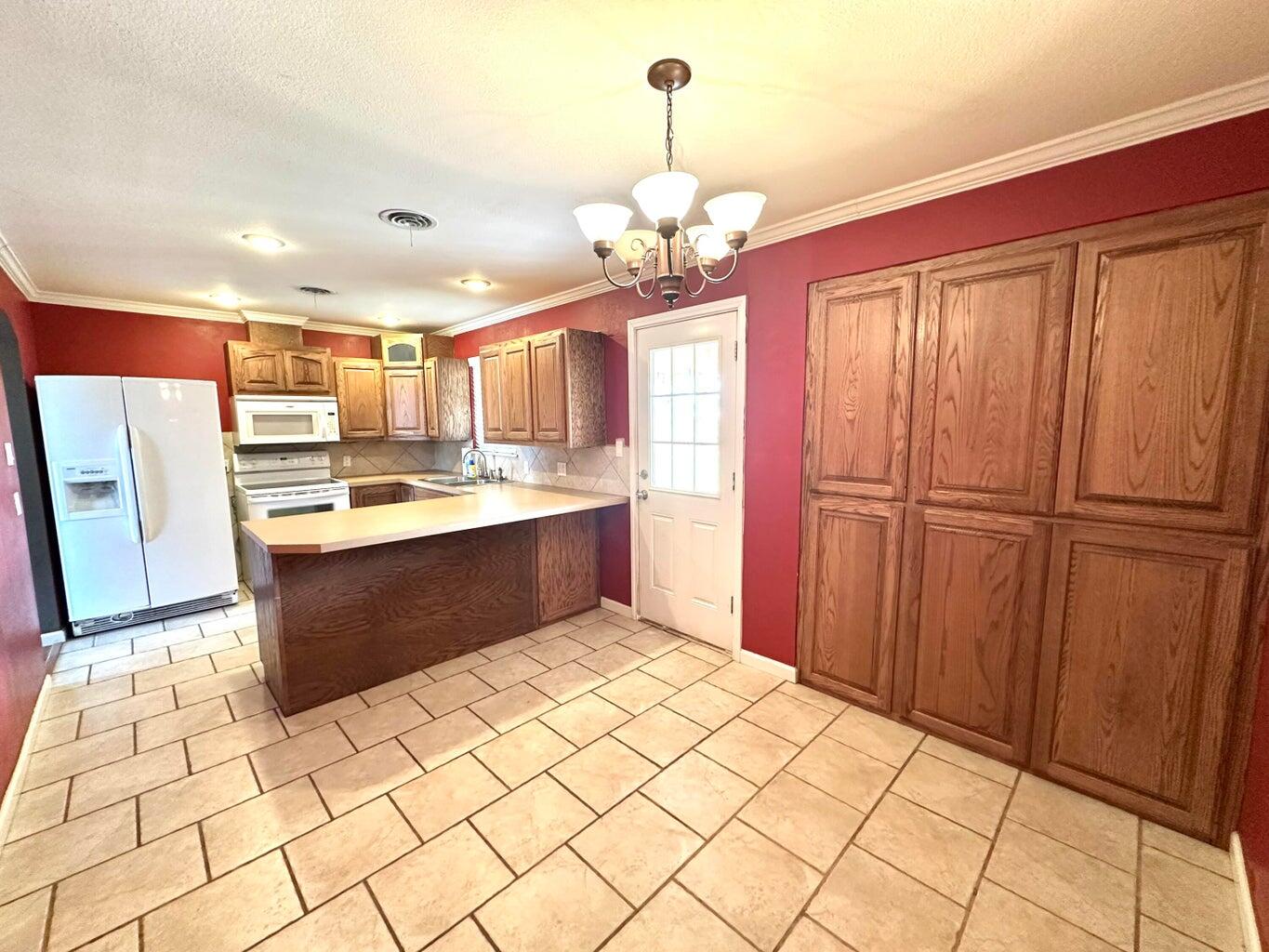 2615 West 19th Plainview, TX 79072 - Photo 5 of 15 a kitchen with stainless steel appliances kitchen island granite countertop a refrigerator and a sink