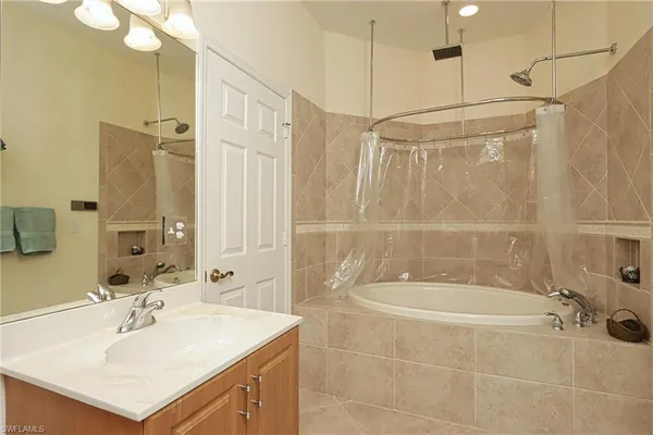 a bathroom with a sink mirror and shower