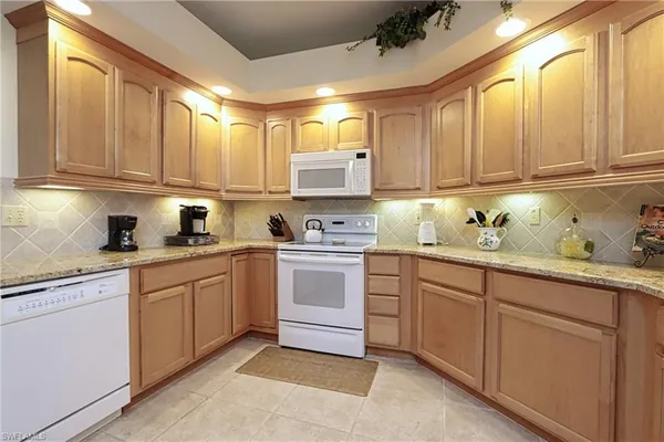 a kitchen with cabinets appliances and a window