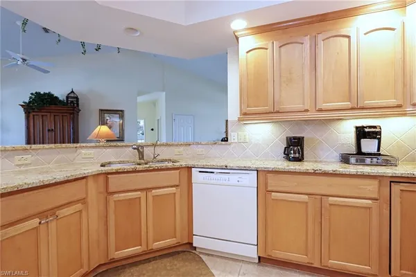 a kitchen with white cabinets and sink